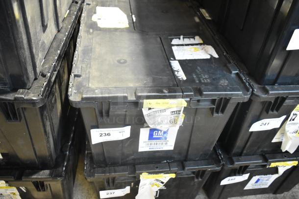 Black poly bin containing brand new car parts and black car mats, labeled with various tags and GM logo, Item 236.