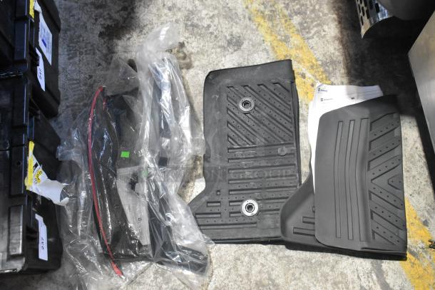 Brand new car parts in poly bin, including black car mats. Parts sealed in plastic, bins labeled with tags.