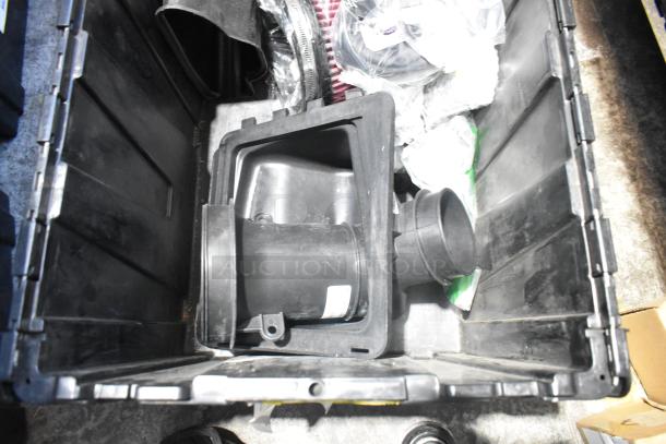 Brand new assorted car parts, including car mats, in black poly bin. Items appear unused and include various components.