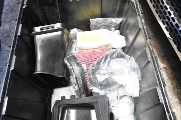 Brand new car parts including air filter, intake duct, and accessories in a black poly bin.