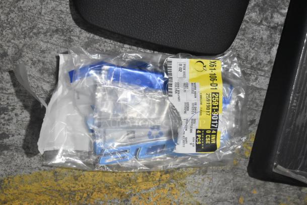 Brand new GM 25958214 tail lamp assembly and emblems in a black poly bin, sealed packaging with visible labels.