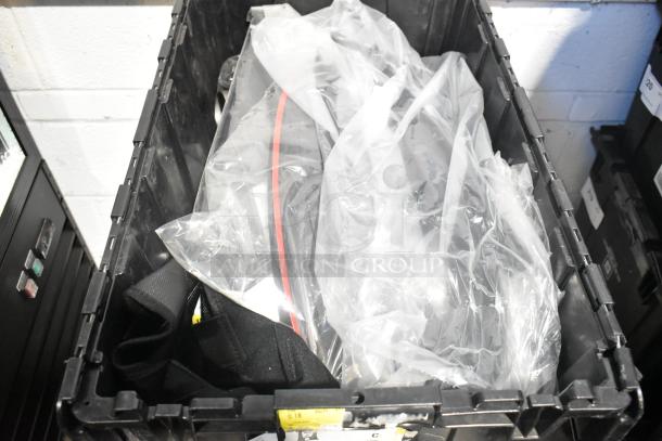 Brand new car parts in black poly bin, plastic-wrapped. Ideal for automotive needs. No visible labels.