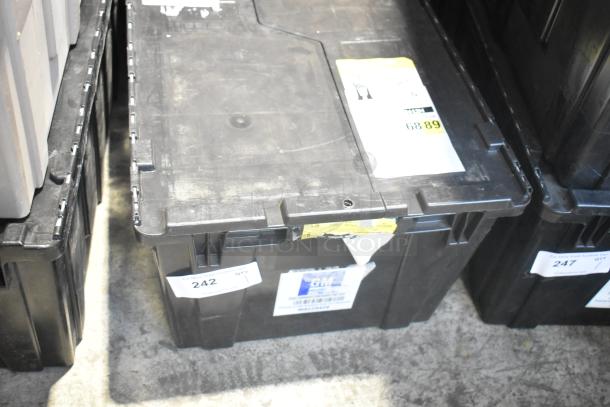 Black poly bin with various car parts including a Camaro bag. Labels display GM logo, item number 242, and condition as brand new.