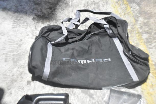 Brand new Camaro bag in black, part of a lot of car parts, housed in a durable black poly bin.