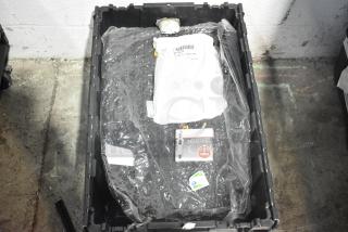 Brand new lot of car parts including spark plugs and a grille, in a black poly bin, with visible packaging and labels.