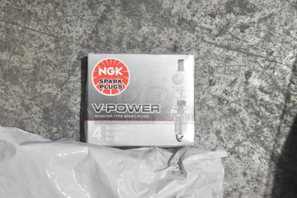 NGK V-Power spark plugs box of 4, part of brand new lot of car parts in black poly bin.