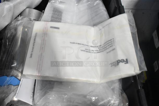 Brand new lot of various car parts in black poly bin, featuring car emblem and pouches. Tags and packaging visible.