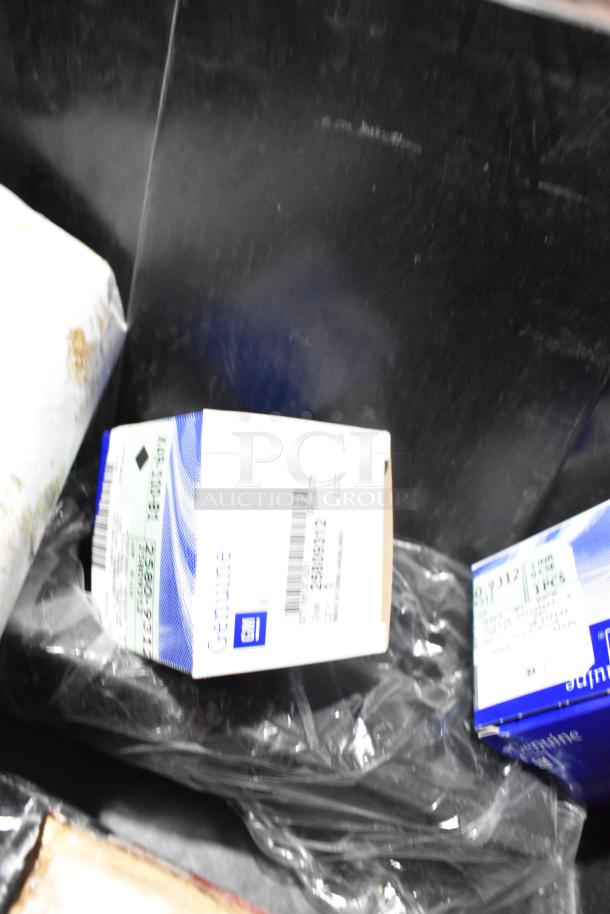 Lot of brand new car parts in black poly bin, including GM Genuine boxes and car mats.
