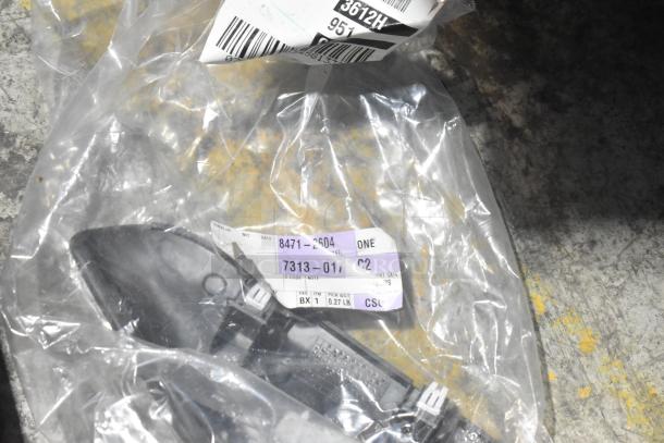 Brand new assorted car parts in clear packaging with tags reading "8471-2604" and "7313-0172C2," in black poly bin.