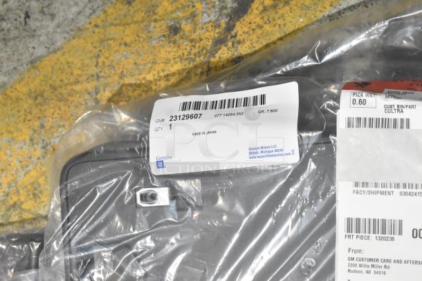 Brand new car parts in black poly bin with car mats. Labels show GM part #23129607, made in Japan.
