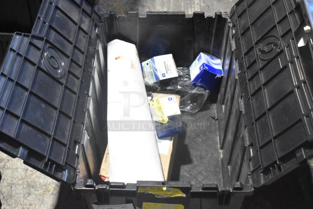 Brand new lot of car parts, including car mats, in a black poly bin. Items have visible GM labels and packaging.