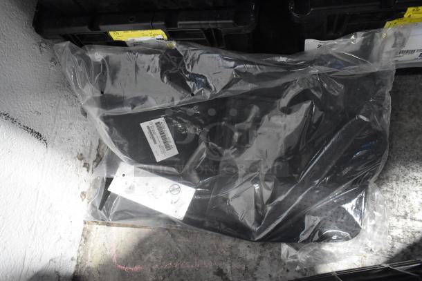 Brand new car parts lot in black poly bin, includes car mats and emblem. Items in sealed packaging with visible labels.