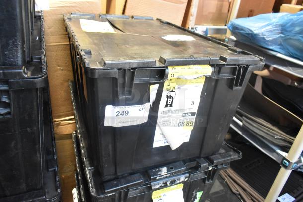 Black poly bin containing brand new car parts including car mats and emblem, labeled with auction tags and lot number 249.