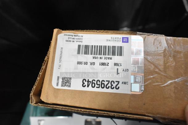 Alt text: "Box of GM Genuine Parts with visible label, part number 23295943. Includes car parts in a black poly bin."