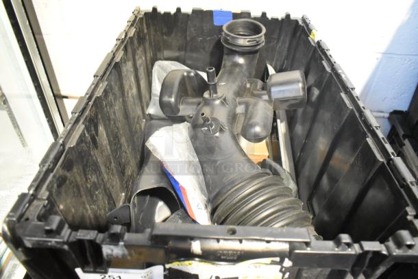 Brand new lot of various car parts in black poly bin, includes side view mirror and rubber components.