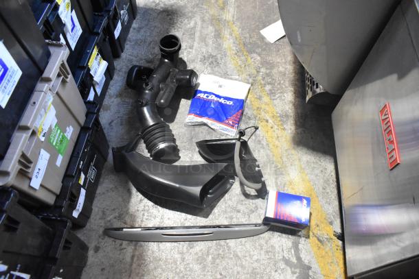 Lot of new car parts including a side view mirror, air duct, and ACDelco packaging in a black poly bin, all in brand new condition.