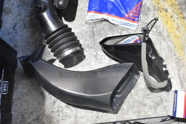 Brand new assortment of car parts in black poly bin, featuring side view mirror, ducts, and ACDelco packaging.