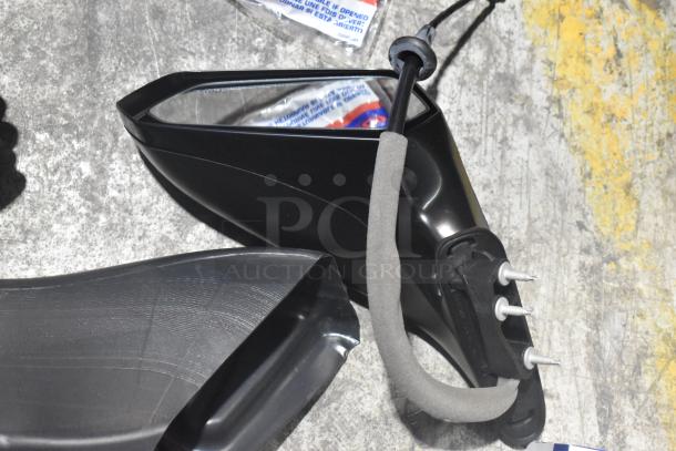 Brand new black side view mirror, part of various car parts lot in poly bin. Features mounting bolts and protective foam.