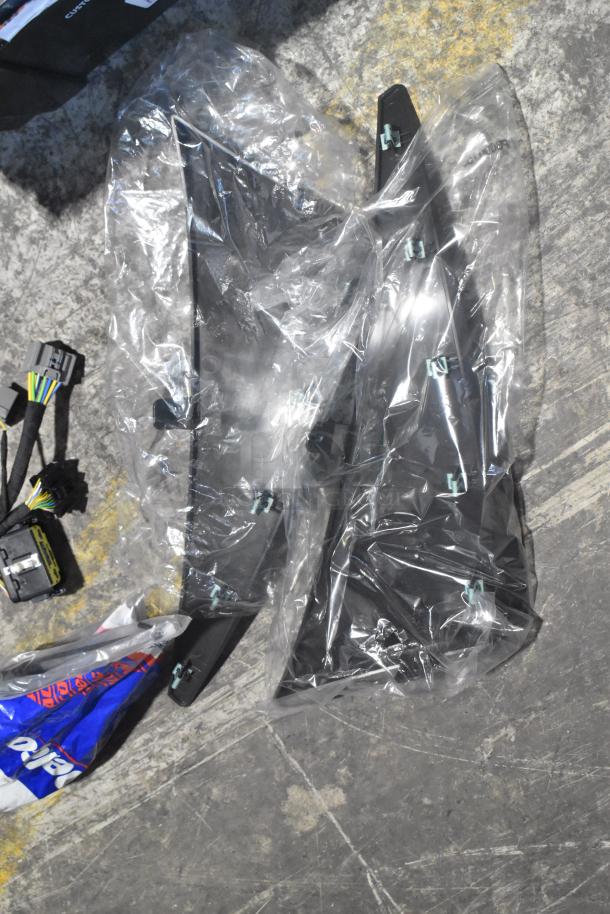 Brand new car parts including filters and panels in transparent wrap and a black poly bin; labels visible.