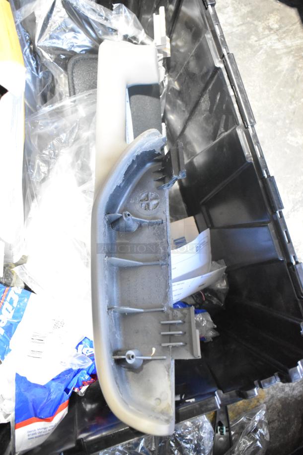 Brand new car parts in a black poly bin, including filters and panels, visible labels and parts in original packaging.