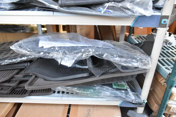 Brand new tier lot of various car parts including packaged car mats on metal shelf, indicating unused condition.