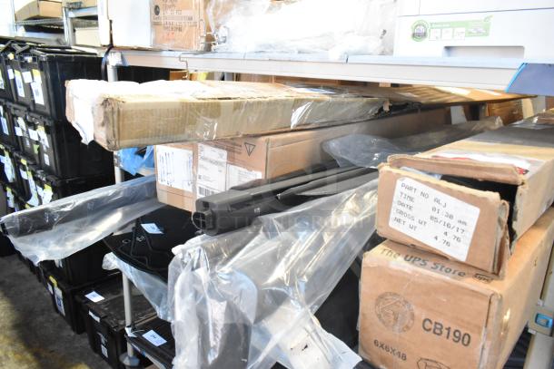 Tier lot of various car parts, including a GM 20862098 mirror assembly, still in original packaging. Boxes with labels on shelves.