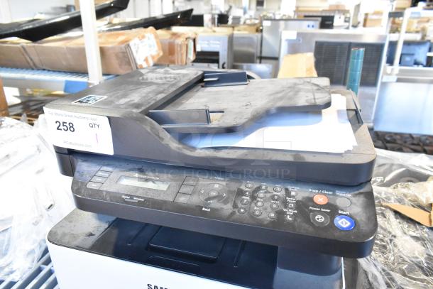 Samsung Xpress M2885FW printer, scanner, copier in fair condition. Auction tag "258" visible. Features control panel.