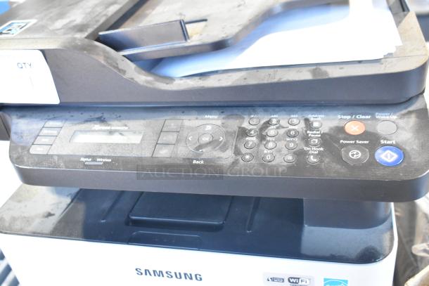 Samsung Xpress M2885FW countertop printer, scanner, copier with keypad and status display, showing signs of use.