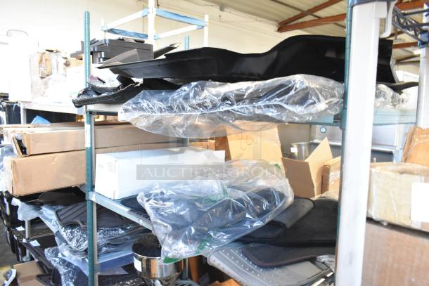 Two-tier shelf of brand new items, including car mats, in original packaging. Items appear in excellent condition.