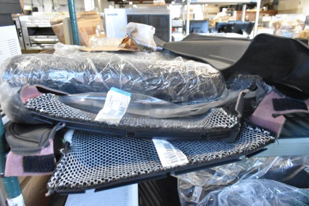 Two-tier lot of brand new items, including car mats. Items wrapped in plastic packaging with visible product tags.