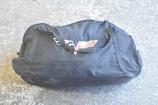 Two-tier lot with a black carrying bag featuring a Corvette logo, containing brand new car mats. Bag in excellent condition.
