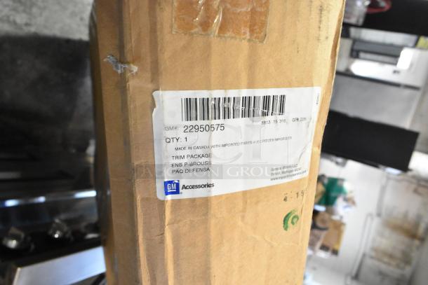 Brand new GM 22950575 front bumper packaging with label showing GM Accessories, barcodes, and item details.