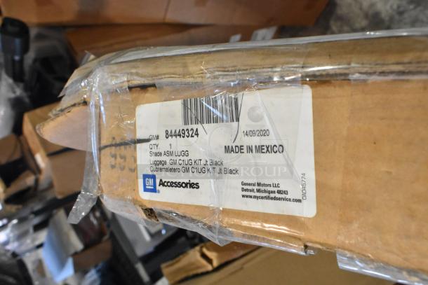 Box with GM parts, including GM 22950575 bumper, GM 22989472 spoiler, GM 19328980 deflector; new, labeled "Made in Mexico."