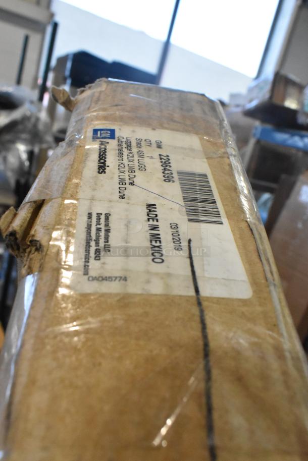 Box with label showing GM part numbers, including GM 22964396. New condition, Made in Mexico. Auction includes bumper, spoiler, deflector.