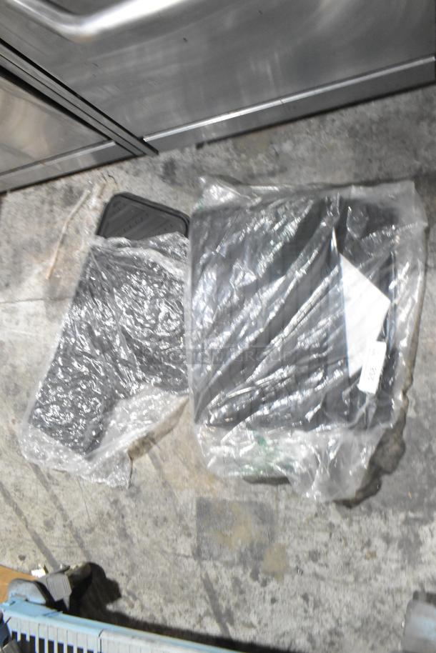Tier lot of brand new car mats in plastic wrap, indicating unused condition.