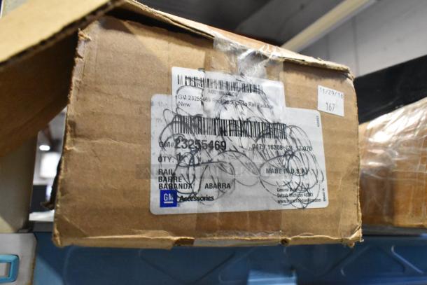 Cardboard box with GM 23255469 Rookrack Cross Rail Package label, marked new. Includes GM logo and "Made in U.S.A."