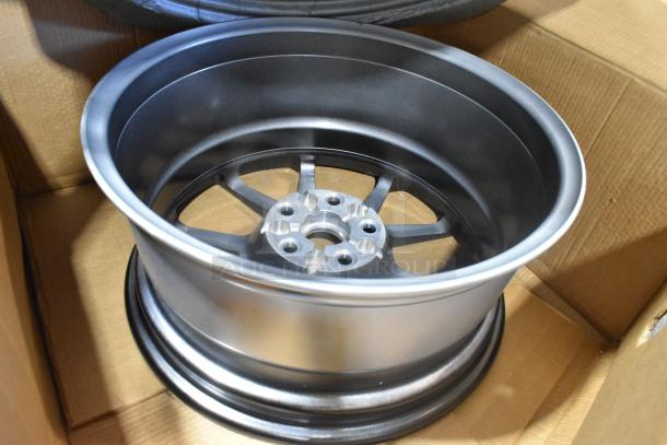 Brand new GM 19303155 rim in silver finish, multi-spoke design, shown in open box, pristine condition.