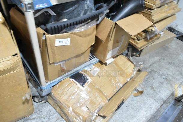 Boxed tier lot containing various new items including car mats; some packaging slightly damaged, labeled "276".