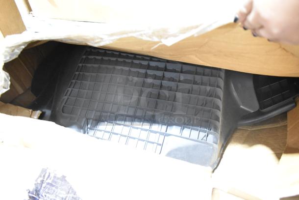 Brand new car mats in packaging, unopened. Durable, grid pattern design, black color. Ideal for vehicle interiors.