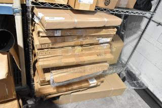 Stack of sealed boxes containing various brand new items, including GM 84370635 floor liner, on metal shelf in a warehouse.