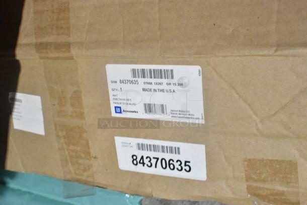 Brown cardboard box with GM label showing part number 84370635, indicating GM floor liner, made in the USA.