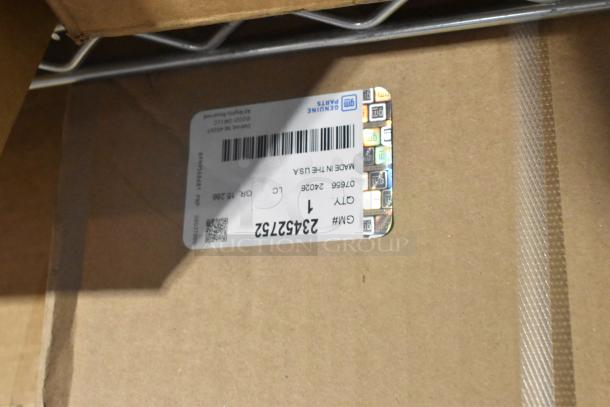 New tier lot of various items in box, featuring GM 84370635 floor liner. Label shows GM Genuine Parts, Made in USA.