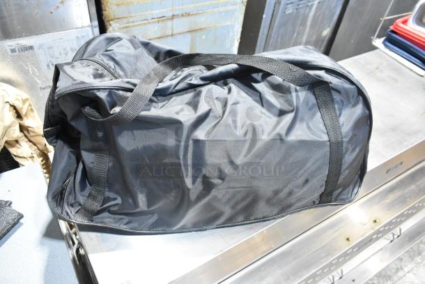 Black nylon bag containing a brand new GM 84162521 third row all-weather rubber floor mat. Bag appears intact and unused.