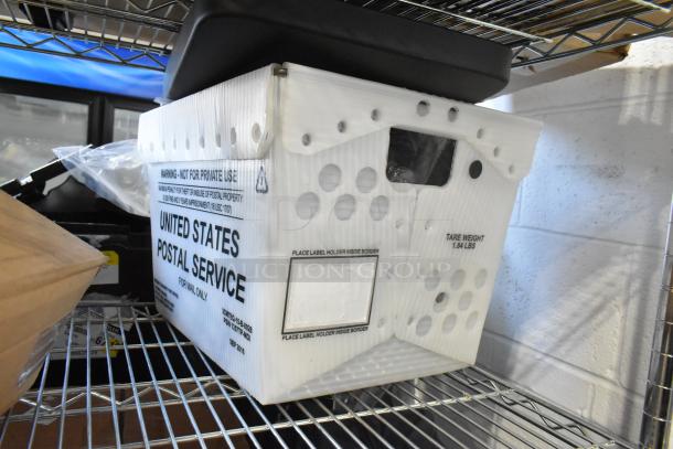 Brand new tiered lot of items in USPS bin, including 100230A Balancer, GM 23473653 valve stem caps, on metal shelf.