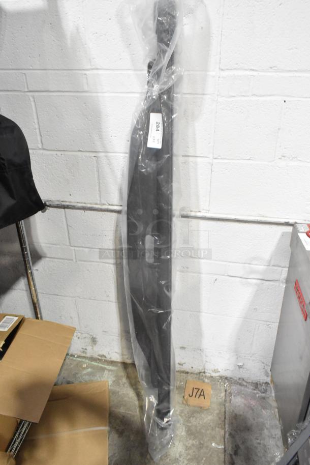 Brand new rail in sealed packaging, standing against a white wall. Label displays "284." Box and shelving nearby.