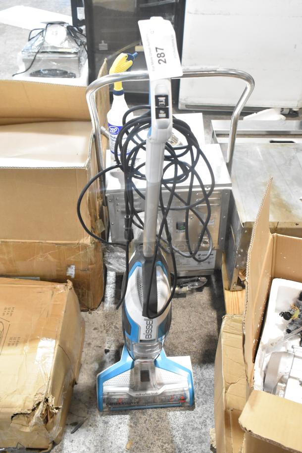 Bissell Multi Surface Brush Vacuum Cleaner, 115 Volts, 1 Phase, in good condition. Includes visible power cord and auction tag marked "287".