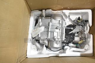 Brand new motor in a cardboard box, encased in white foam packaging. Silver finish with visible wiring and components.