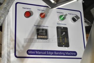 Brand new mini manual edge banding machine with scratch and dent, featuring power controls, temperature and speed controllers.