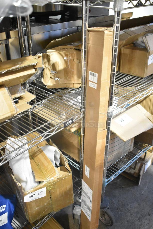 Boxes with minor damage on metal shelf containing a brand new heavy duty spring loaded gate caster and cordless cellular shades. Tags show inventory labels.