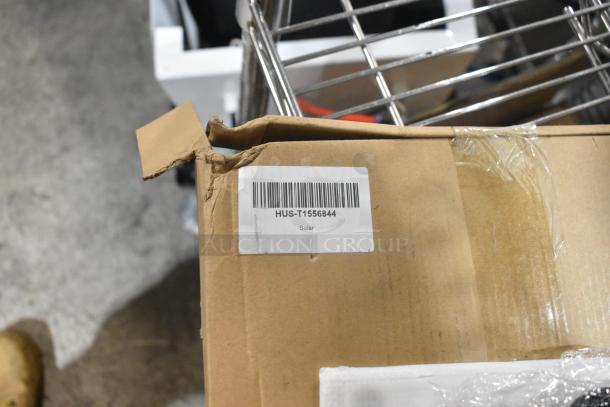 Cardboard box with visible barcode label "HUS-T1556844 Solar," indicating part of a scratch and dent auction lot.